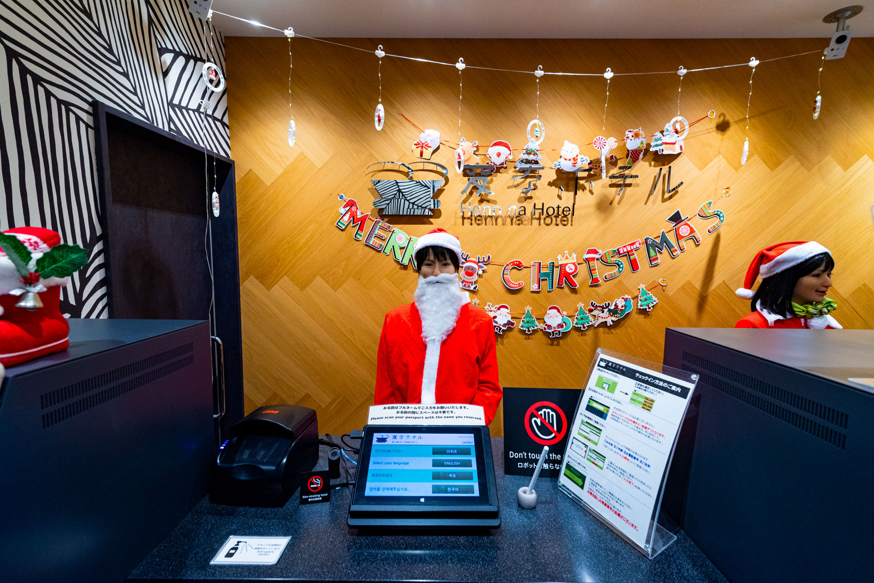 Festively decorated reception at Henn na Hotel in Tokyo Akasaka Japan, with robot staff dressed as Santa Claus during the Christmas season.