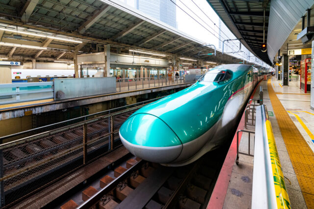 Green and white Shinkansen bullet train at the platform of Tokyo Station in Japan