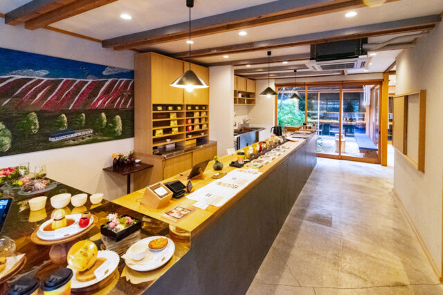 Interior of Unir Coffee Kyoto with wooden counter, coffee displays, and garden view through glass doors