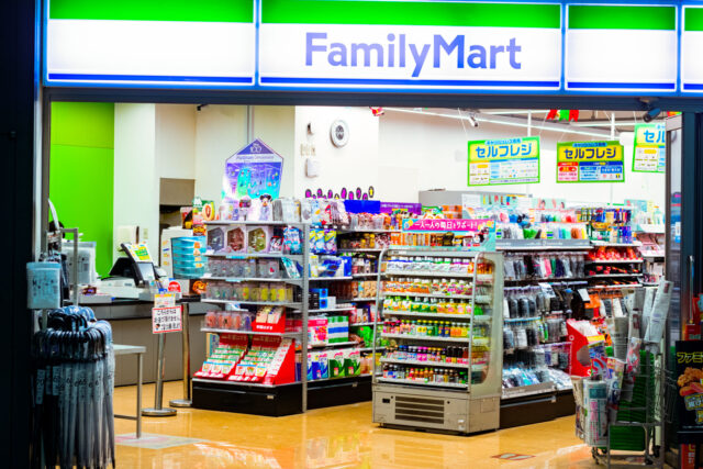 FamilyMart convenience store entrance in Japan, brightly lit with shelves of drinks, snacks, and daily goods visible inside.