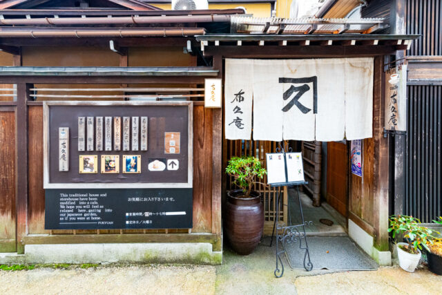 Entrance of Fukuyan Café in Kyoto, a traditional Japanese house converted into a café, with wooden walls, noren curtain, and menu board outside.