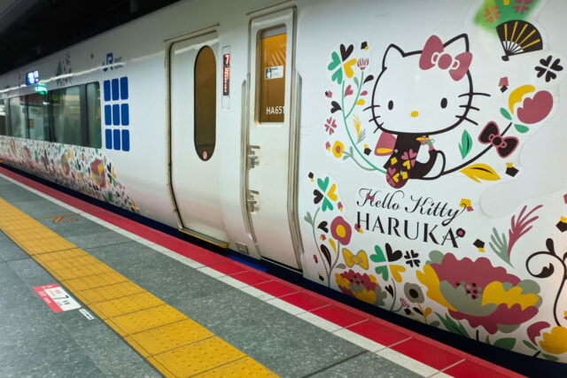 Exterior of the Hello Kitty Haruka train at the platform, featuring Hello Kitty in a kimono surrounded by floral patterns.