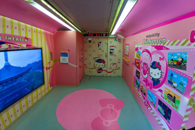 Colorful Hello Kitty Shinkansen included in Japan Rail Pass interior with themed pink walls, route maps, and decorative signage in Japan.