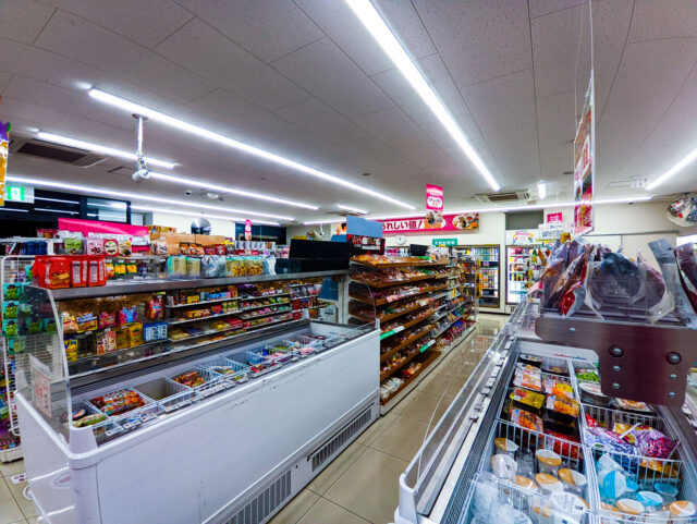 Interior of a Japanese convenience store with shelves full of snacks, drinks, and daily essentials.