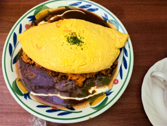 Japanese omurice topped with a fluffy omelet, served over ketchup-seasoned rice with rich demi-glace sauce