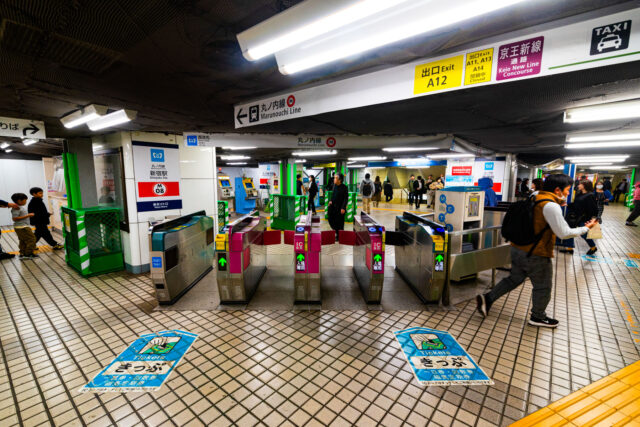 Ticket gates at Shinjuku Station Marunouchi Line in Tokyo with passengers entering and exiting the metro concourse.