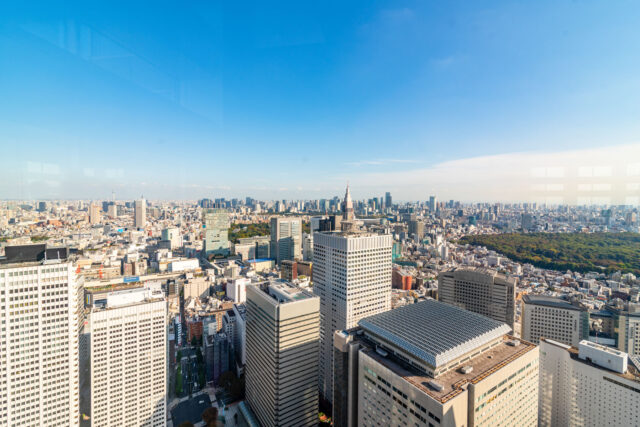 Panoramic view of Tokyo Shinjuku skyscrapers from the Tokyo Metropolitan Government Building observatory with Shinjuku Gyoen park in the distance to the right.