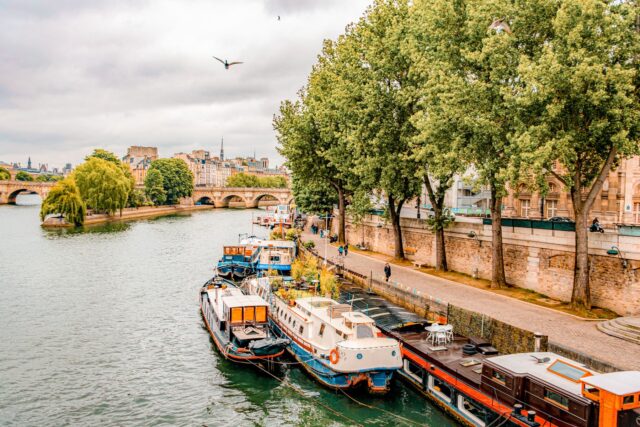 Houseboats and sightseeing boats along the Seine near Pont Neuf, Paris. Included in the Paris Pass